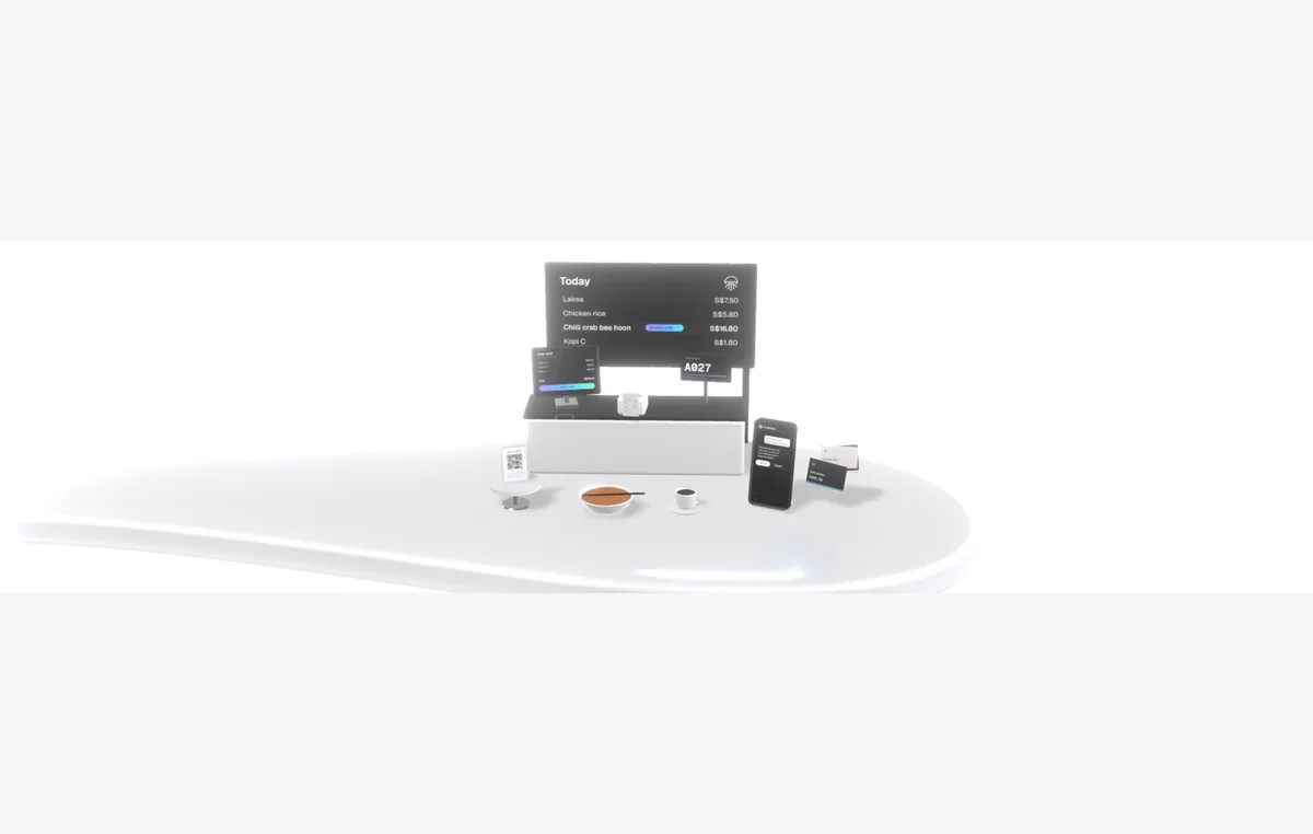 A café counter with a tablet showing orders, a QR ordering stand, a receipt printer and a phone open on a WhatsApp chat